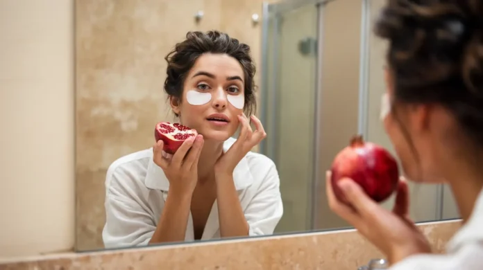 beautiful miss with pomegranate and under-eye patches near mirror in bathroom